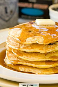 a stack of pancakes with syrup and butter on top