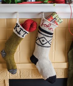 two stockings hanging from a mantel with yarn and balls of yarn in them on the mantle