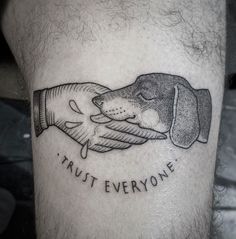 a black and white photo of a dog holding another dog's hand with trust everyone written on it