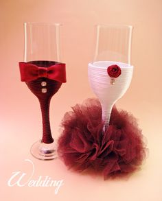 two wine glasses decorated with red and white tulle