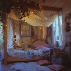 a bedroom with fairy lights strung from the ceiling and curtains on the windowsills