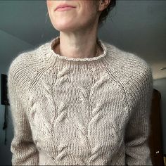 a woman is wearing a sweater and posing for the camera