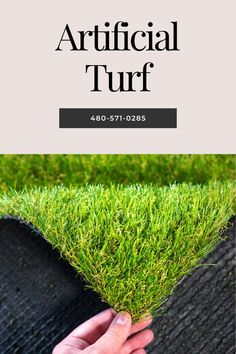 the artificial turf is being held up by someone's hand on top of it