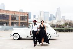 a man and woman standing in front of a white car