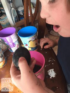 a young boy is playing with an ice cream cone in his pink cup and making it look like he's having fun