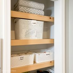 an organized closet with baskets and towels