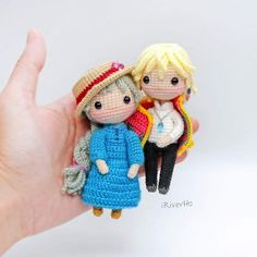 two tiny knitted dolls sitting on top of each other's fingers in front of a white background