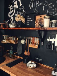 a kitchen with chalkboard walls and wooden counter tops, along with utensils