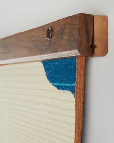 a close up of a wooden frame with a blue and white rug on it's side