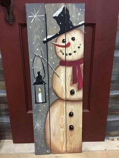 a wooden door with a snowman painted on it