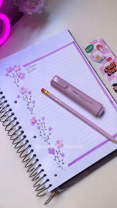 a pink pen sitting on top of a notebook