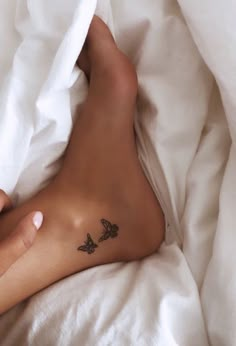 a person laying in bed with a tattoo on their left leg and the other foot