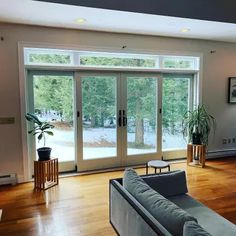 a living room filled with furniture and large windows