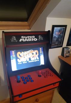 an old fashioned video game sitting on top of a wooden dresser next to a wall