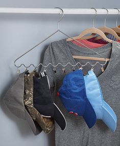 several hats are hanging on a rack in front of a t - shirt and hat hanger