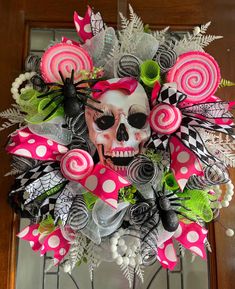 a wreath decorated with pink and black candy canes, skulls and flowers is displayed on the front door