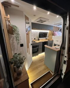 the interior of a camper van with its door open to reveal a kitchen and living area