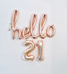 some balloons that say hello 21 and are in the shape of letters on a white surface