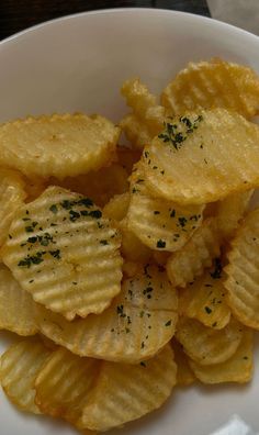 a white bowl filled with potato chips on top of a table