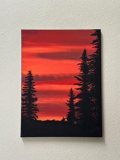 an acrylic painting of pine trees against a red and orange sky with clouds