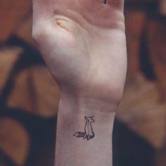 a small fox tattoo on the wrist