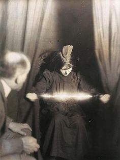 an old black and white photo of a person sitting in a chair holding a light saber