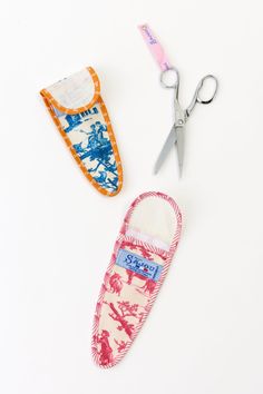 two pairs of scissors and slippers on a white surface