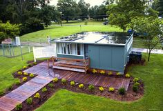 a small house sitting in the middle of a lush green field with stairs leading up to it