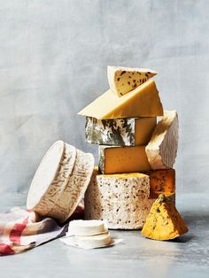 several different types of cheese stacked on top of each other with one piece cut off