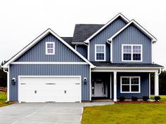 a blue house with white trim and two car garages on the front door is shown