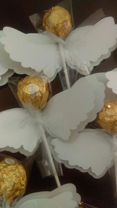 some white and gold foiled chocolate candies in clear wrappers on a table