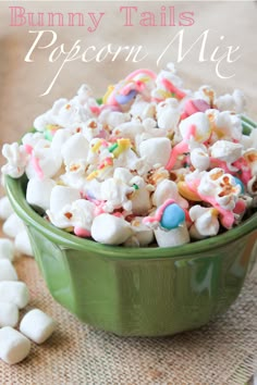 a green bowl filled with marshmallows on top of a table