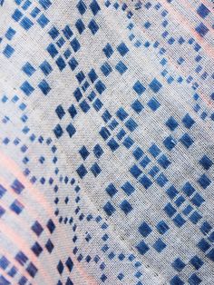 an up close shot of the blue and white pattern on a fabric material that looks like it has been woven