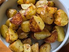 a white bowl filled with cooked potatoes on top of a table