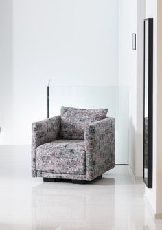 a chair that is sitting in the middle of a room with white walls and flooring