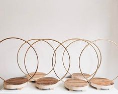 four wooden circles sitting on top of a white table next to each other in front of a wall