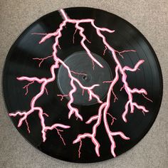 a black record with pink lightning on it