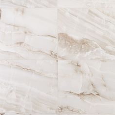 a white marble tile wall that looks like it has been painted in different shades and sizes