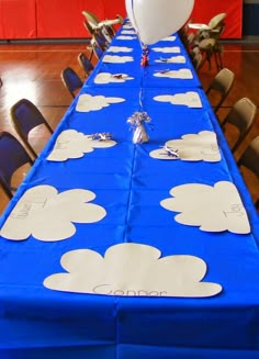 a blue table with white clouds on it and a balloon in the air at the top