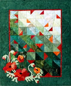 a quilted wall hanging with flowers and leaves on it's side, in the shape of a square