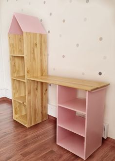 a wooden desk and shelf in a room with polka dots on the wall behind it