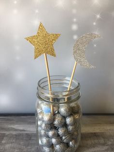 a jar filled with chocolate covered candies and two gold stars on top of them