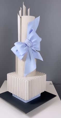 a three tiered cake with blue bows on top