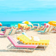 many beach chairs and umbrellas on the beach