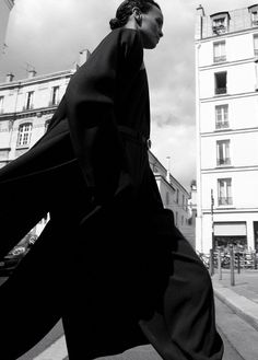 black and white photograph of a man walking down the street