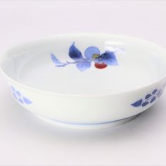 a white bowl with blue and red flowers on it