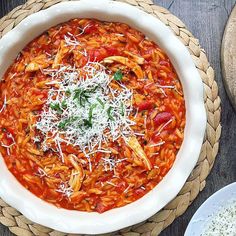 a bowl of pasta with parmesan cheese on top