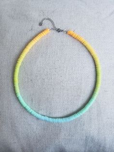 a yellow and blue necklace on top of a pillow