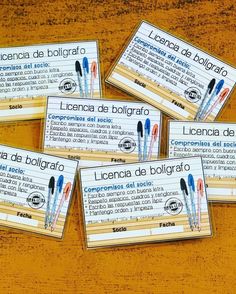 four business cards with writing on them sitting on a wooden table in spanish and english