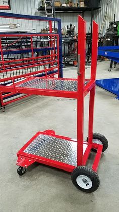 two red dollys with wheels in a warehouse